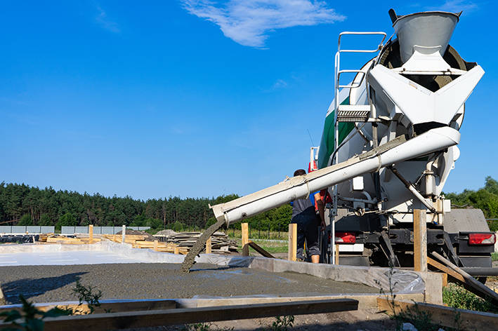 Workers pour the Foundation for the construction of a residential building using mobile concrete mixers.